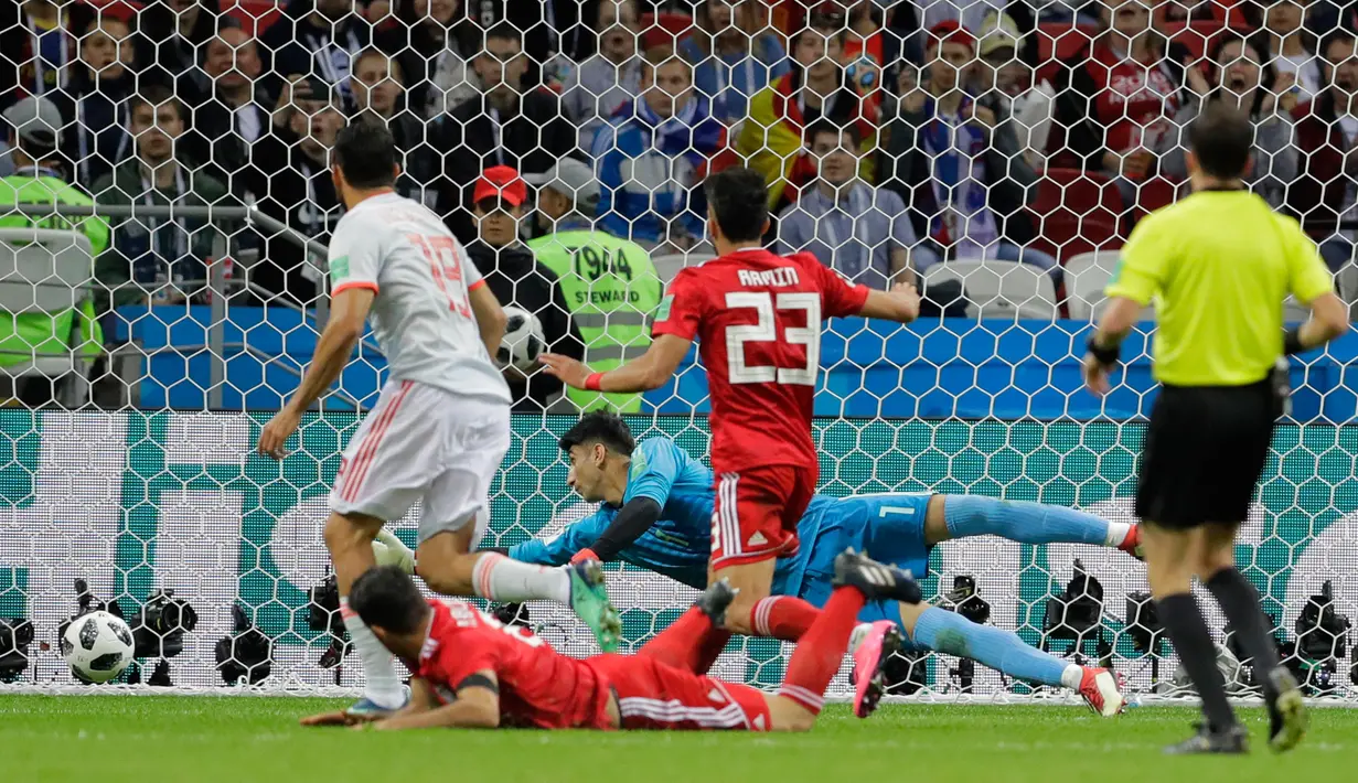 Penjaga gawang Iran, Ali Beiranvand berusaha menangkap bola yang masuk ke gawangnya saat melawan Spanyol dalam penyisihan Grup B Piala Dunia 2018 di Kazan Arena, Kazan, Rusia, Rabu (20/6).  (AP Photo/Sergei Grits)