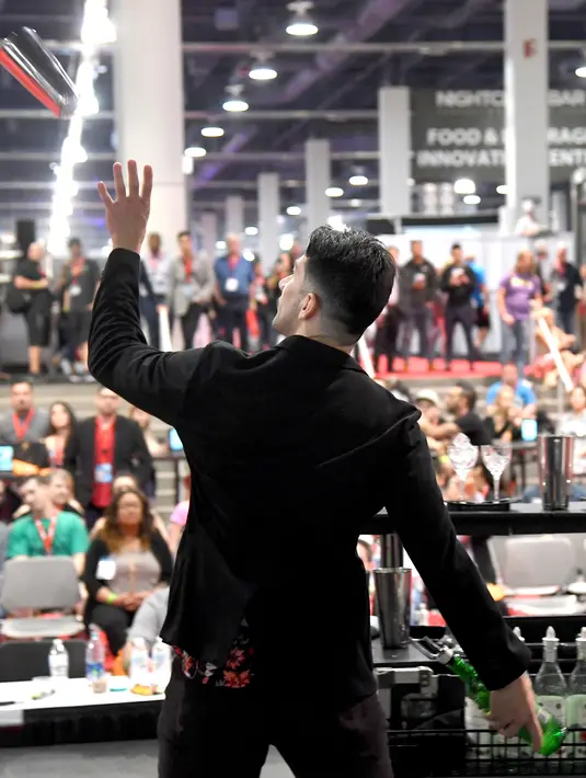 Bartender Cruz Guitierrez saat berkompetisi dalam Shake It Up Flair Competition pada hari kedua dari Nightclub & Bar Convention and Trade Show tahunan ke-34 di Las Vegas, Nevada (26/3). (AFP Photo/Ethan Miller)