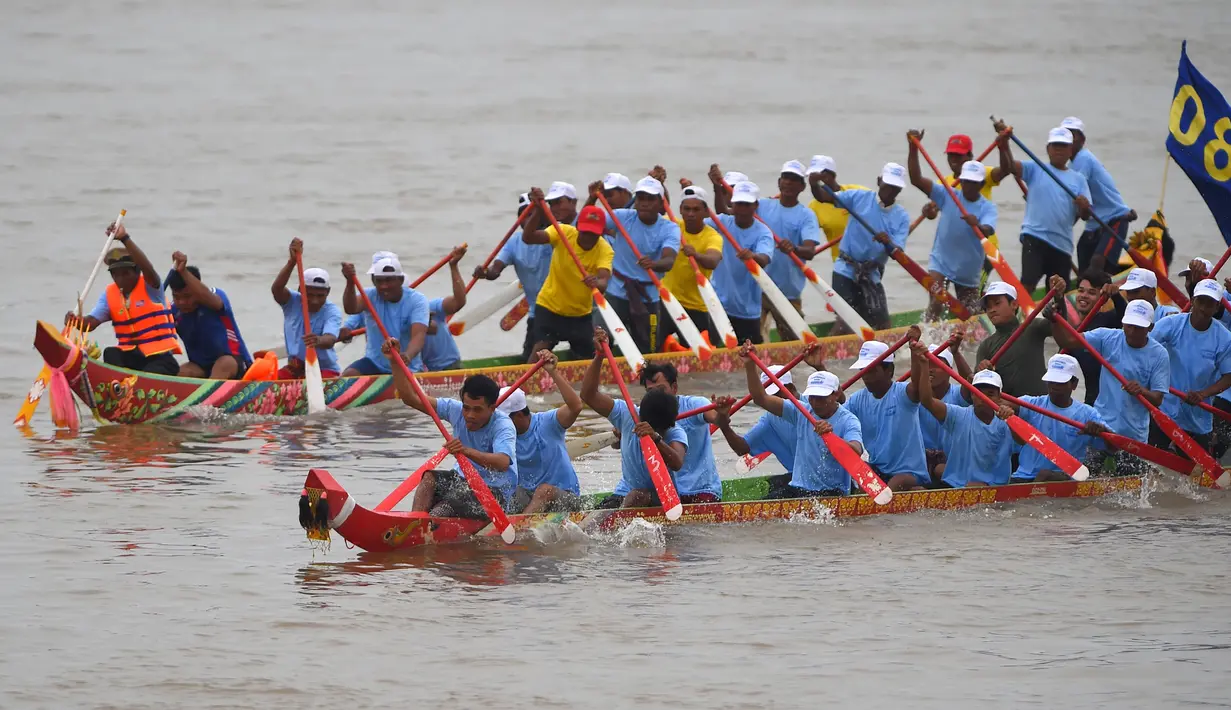 Peserta mendayung perahu naga menuju garis finish selama Festival Air di sungai Tonle Sap, Phnom Penh, Senin (11/11/2019). Cambodian Water Festival atau Bon Om Touk yang digelar pada 10-12 November ini merupakan salah satu festival terbesar dan paling populer di Kamboja. (TANG CHHIN Sothy/AFP)