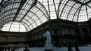 Orang-orang  berseluncur di arena ice skating di bawah kubah kaca mewah legendaris, Grand Palais, Paris, Senin (17/12). Arena ice skating musiman ini terbuka untuk umum selama liburan Natal. (AP Photo/Christophe Ena)