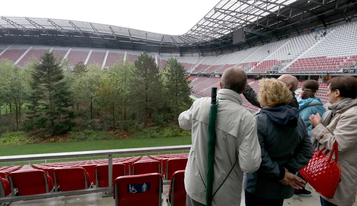 Pengunjung melihat instalasi ekosistem hutan di Stadion Woerthersee, Austria, Minggu (8/9/2019). Lebih dari 300 pohon berbagai jenis , mulai dari pohon aspen, ek, betula, hingga larix ditancapkan dalam karya seni yang berjudul "The Unending Attraction of Nature". (AP/Ronald Zak)
