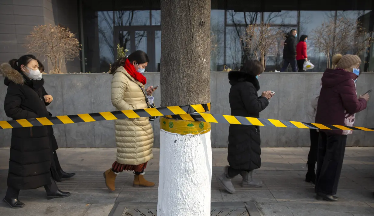 Orang-orang yang memakai masker pelindung berbaris untuk pengujian massal COVID-19 di Beijing, China, Jumat (22/1/2021). Beijing memerintahkan pengujian COVID-19 untuk sekitar dua juta orang menyusul kasus baru. (AP Photo/Mark Schiefelbein)