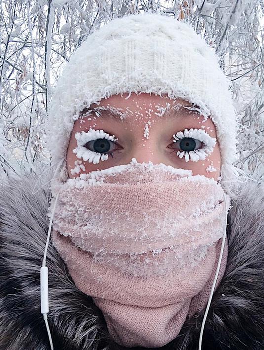 Anastasia Gruzdeva berswafoto dengan bulu mata yang membeku saat menerjang jalanan berselimut es di desa Oymyakon, Rusia, Minggu (14/1). Suhu di sana turun hingga -62 derajat Celcius yang cukup dingin untuk membekukan bulu mata (sakhalife.ru photo via AP)