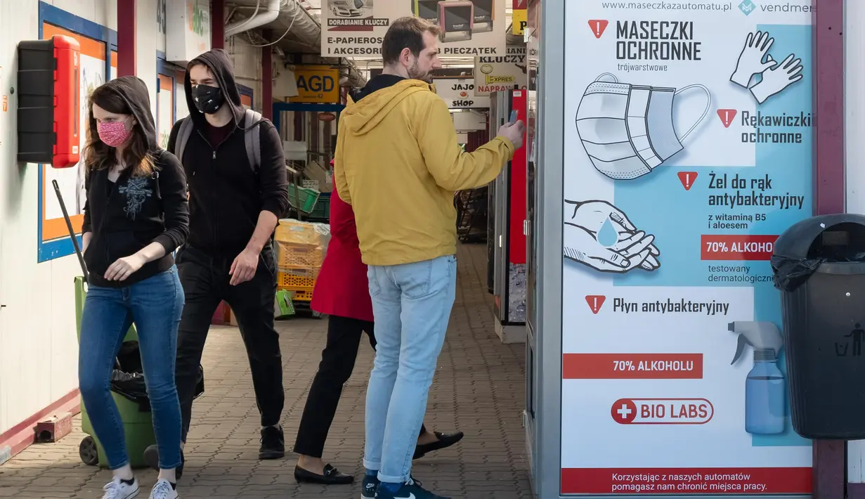 Seorang pria membeli produk dari mesin penjual otomatis yang menjual masker, sarung tangan, dan cairan pembersih tangan di Warsawa, Polandia, Sabtu (11/4/2020). Kementerian Kesehatan Polandia mencatatkan 6.088 kasus virus corona COVID-19 dengan 195 kematian. (Xinhua/Zhou Nan)