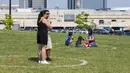 Sejumlah orang tetap berada dalam lingkaran jaga jarak fisik yang dicat di rumput sembari menikmati es krim mereka saat Festival Es Krim Toronto di Toronto, Kanada, Sabtu (15/8/2020). Festival Es Krim Toronto diadakan pada 15-16 Agustus 2020 di tengah pandemi COVID-19. (Xinhua/Zou Zheng)