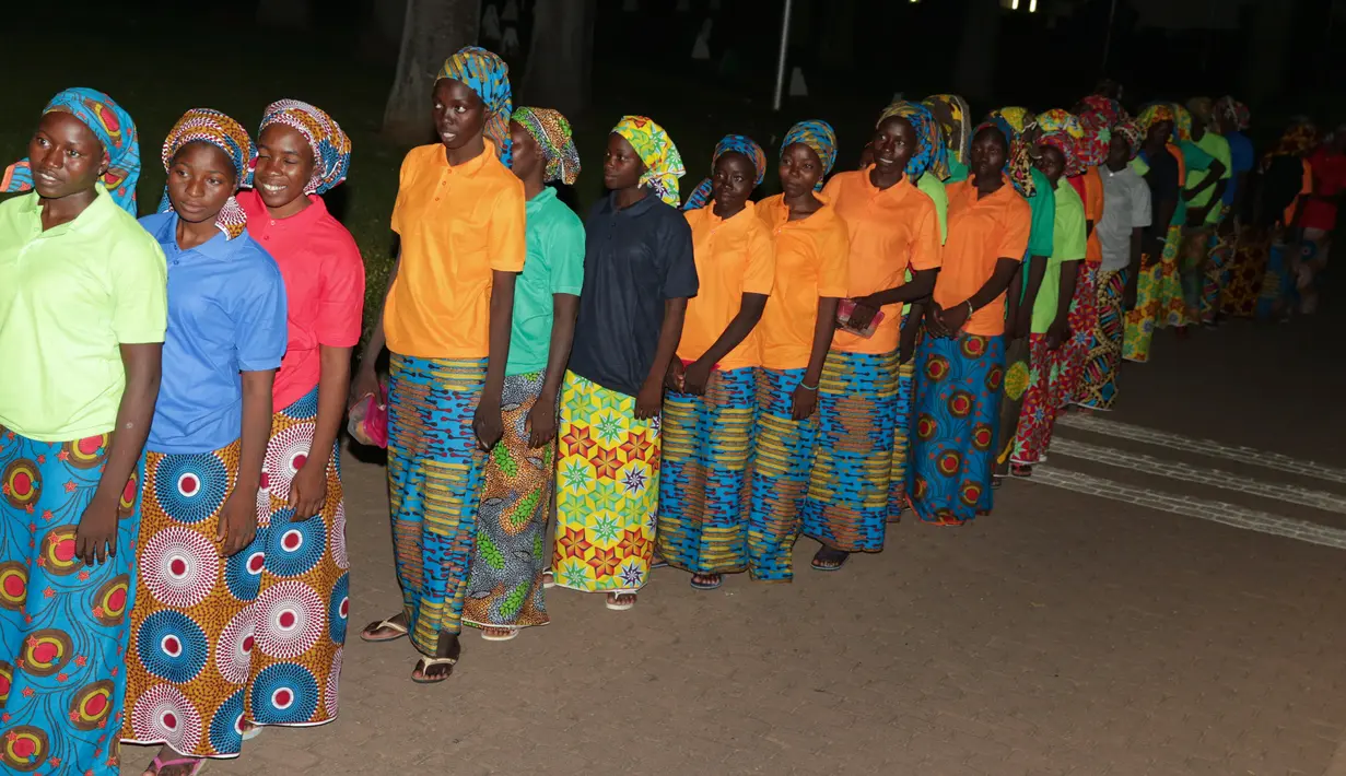 Sejumlah gadis sekolah Chibok berbaris untuk bertemu Presiden Muhammadu Buhari di Abuja, Nigeria (7/5). Para siswi tersebut dibebaskan dan diserahkan dalam pertukaran dengan tahanan Boko Haram. (AFP Photo/PGDBA&HND Mass Communication)