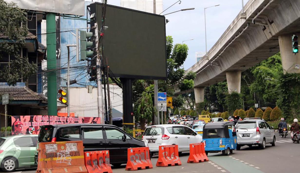 Kendaraan melintas di depan sebuah videotron di simpang Jalan Iskandarsyah, Jakarta Selatan, Minggu (2/10). Garis polisi terpasang terkait insiden videotron itu yang sempat memutar tayangan porno pada Jumat, 30 September 2016. (Liputan6.com/Helmi Afandi)