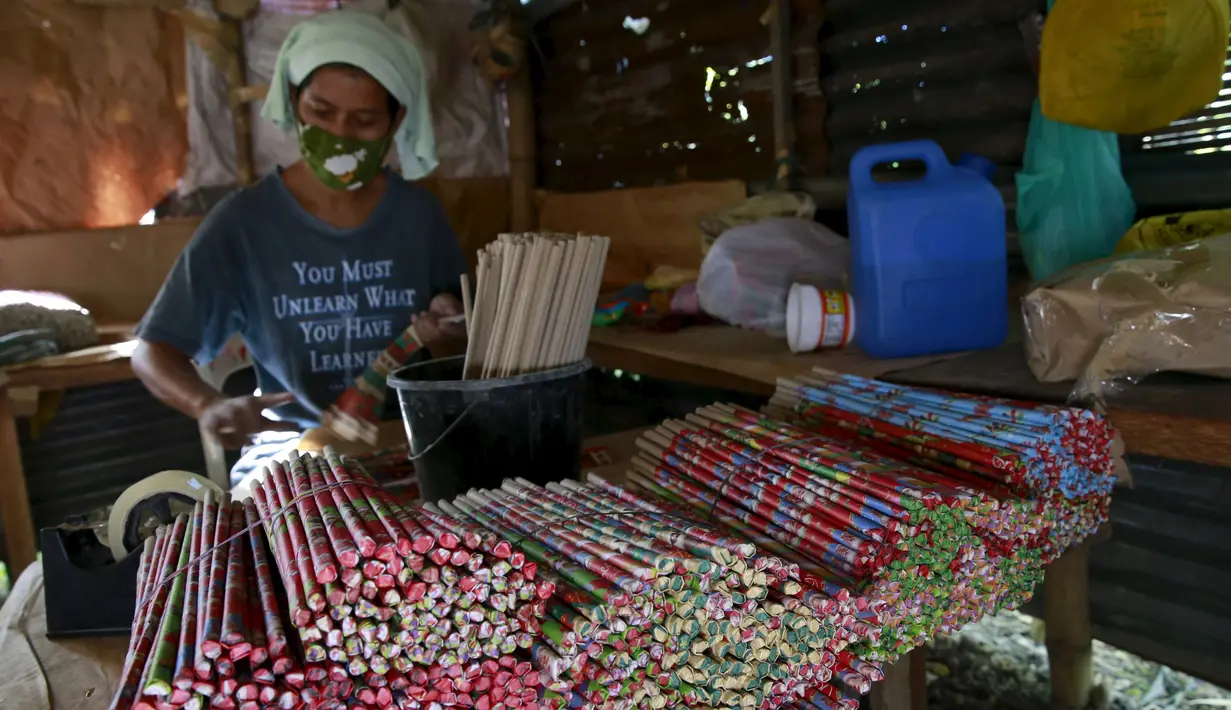 Seorang pekerja membungkus kembang api dengan plastik sebelum dikirim ke toko di kota Bocaue, provinsi Bulacan, Filipina, (26/12/2015). (REUTERS/Romeo Ranoco)
