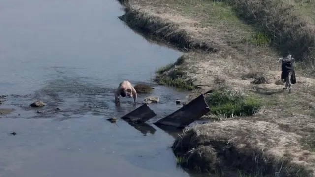 Potret Warga Korea Utara Mandi di Sungai Dekat Rumahnya.