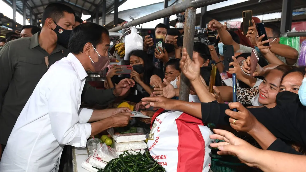 Presiden Joko Widodo atau Jokowi membagikan bantuan langsung tunai bagi para pedagang kaki lima dan warung di Pasar Kebun Lada Kota Binjai, Sumatera Utara, Jumat (4/2/2022).