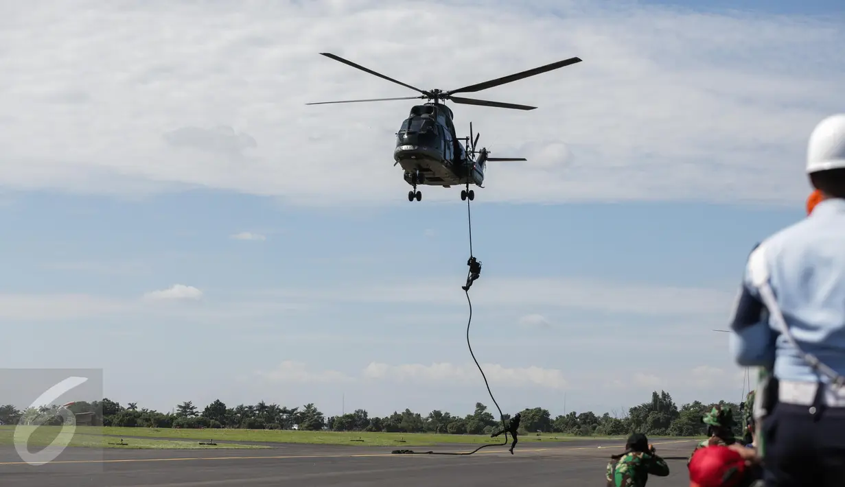 Anggota Paskhas (Pasukan Khas) TNI AU menuruni helikopter menggunakan tali saat unjuk kebolehan simulasi penyelamatan sandera dalam rangkaian acara HUT TNI AU di Halim Perdanakusuma, Minggu (9/4). TNI AU memperingati HUT ke-71 (Liputan6.com/Faizal Fanani)