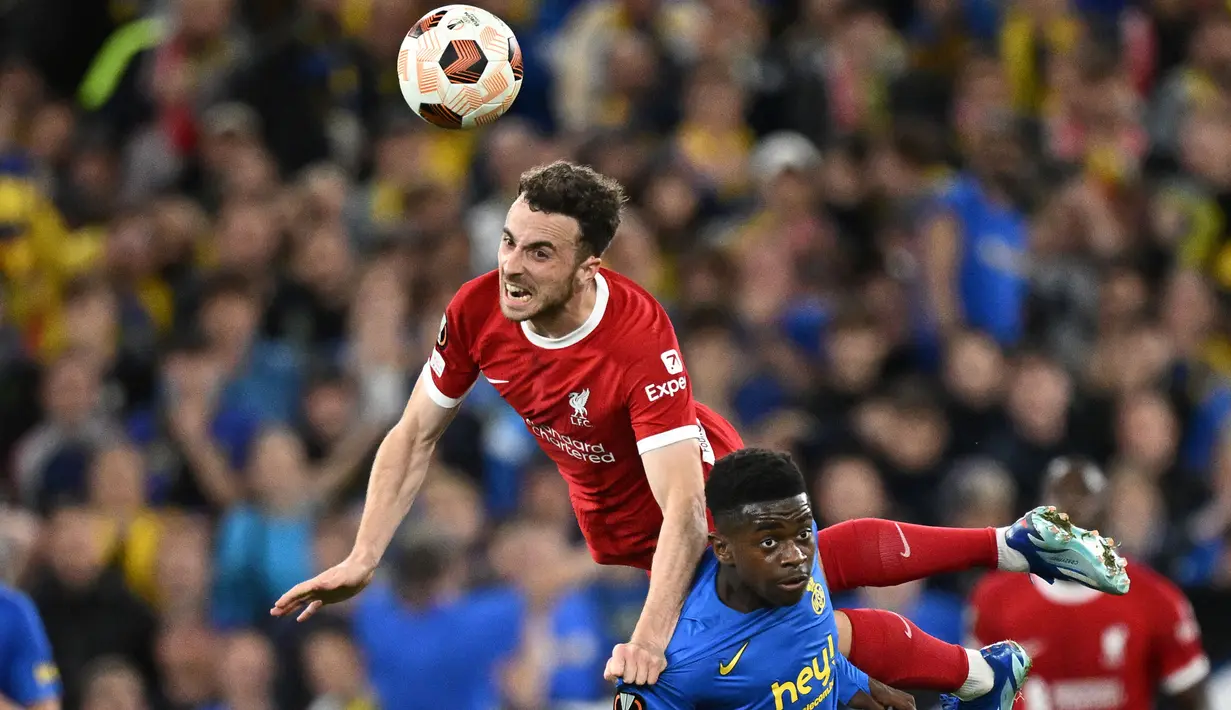 Pemain Liverpool, Diogo Jota (kiri) berebut bola dengan pemain Union Saint-Gilloise, Noah Sadiki sebelum mencetak gol kedua timnya pada laga Grup E Liga Europa 2023/2024 yang berlangsung di Anfield, Inggris, Jumat (6/10/2023) dini hari WIB. (AFP/Oli Scarff)