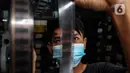Adul (29) mengecek kualitas film seluloid 35mm untuk pertunjukan layar tancap di gudang rumahnya di Jakarta, Rabu (28/4/2021). (Liputan6.com/Johan Tallo)