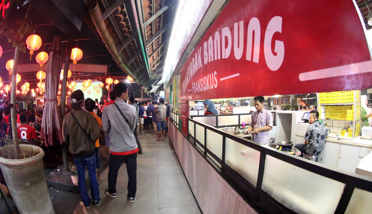 Suporter menonton  sambil menikmati martabak Bandung saat acara nonton bareng Liga Premier Inggris antara Liverpool vs Manchester United di Mall Sumarecon Bekasi, Jawa Barat, Minggu (17/1/2016). (Bola.com/Nicklas Hanoatubun)