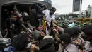 Polisi dan tentara menjaga masyarakat Papua yang memperingati Operasi Trikora 19 Desember 1961 di Patung Kuda, Jakarta, Sabtu (19/12/2020). Massa juga menuntut penghentian rasisme dan politik rasial. (Liputan6.com/Johan Tallo)