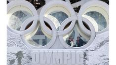 Warga berada di antara logo Olimpiade yang terdapat di luar National Olympic Stadium, Tiongkok, Senin (2/1/2012). Stadium itu rencananya akan digunakan sebagai tempat upacara pembukaan dan penutupan Olimpiade Musim Dingin 2022. (EPA/How Hwee Young).