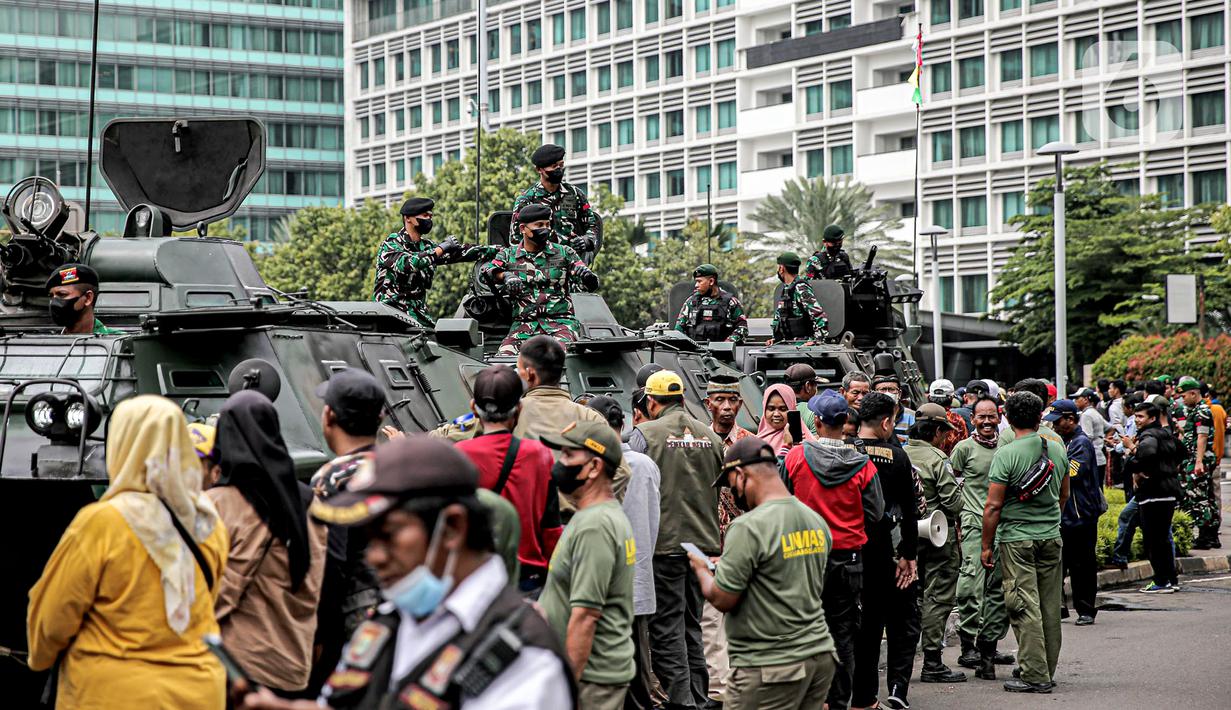 Tentara berdiri di atas alat utama sistem senjata (alutsista) saat perayaan HUT ke-77 TNI di Bundaran HI, Jakarta, Rabu (5/10/2022). Kegiatan yang diikuti oleh seluruh kesatuan jajaran TNI ini dalam rangka menyambut HUT ke-77 TNI. (Liputan6.com/Faizal Fanani)