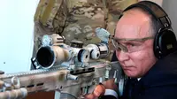 Presiden Rusia, Vladimir Putin menguji coba senapan sniper saat mengunjungi pameran Kalashnikov Concern di Patriot Park, luar Moskow, Rabu (19/9). Tembakan Putin menghantam target yang jaraknya 600 meter. (Alexei Nikolsky, Sputnik, Kremlin Pool via AP)