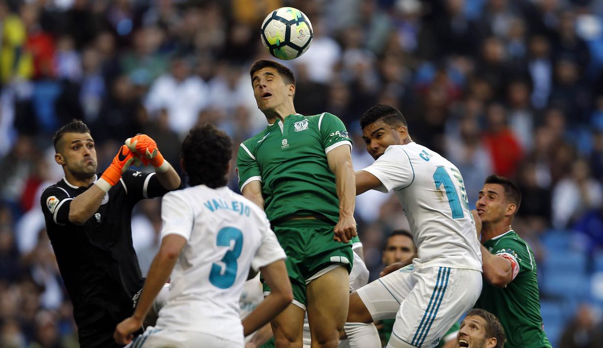 Bek Leganes, Unai Bustinza, menyundul bola saat melawan Real Madrid pada laga La Liga di Santiago Bernabeu, Sabtu (28/4/2018). Real Madrid menang 2-1 atas Leganes. (AP/Francisco Seco)
