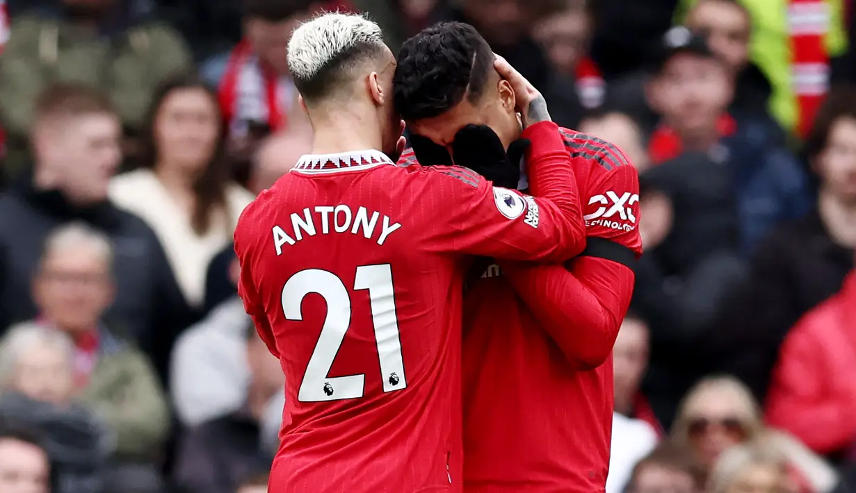Pemain Manchester United, Antony, berusaha menenangkan Casemiro yang menerima kartu merah saat pertandingan melawan Southampton di Stadion Old Trafford, Minggu (12/3/2023). (AFP/Darren Staples)