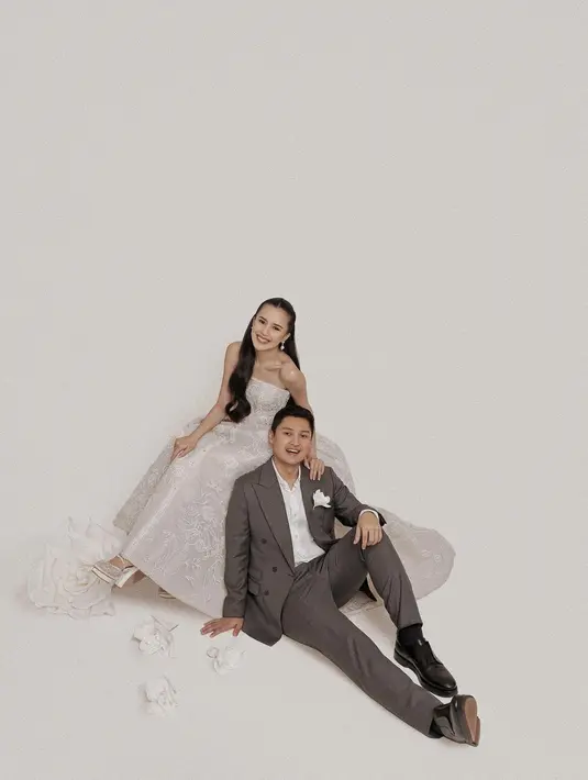 Beby Tsabina tampil cantik kenakan strapless ballgown putih dengan bordir full bunga. Sedangkan Rizki Natakusumah kenakan setelan jas abu-abu dan kemeja putih [@bebytsabina]