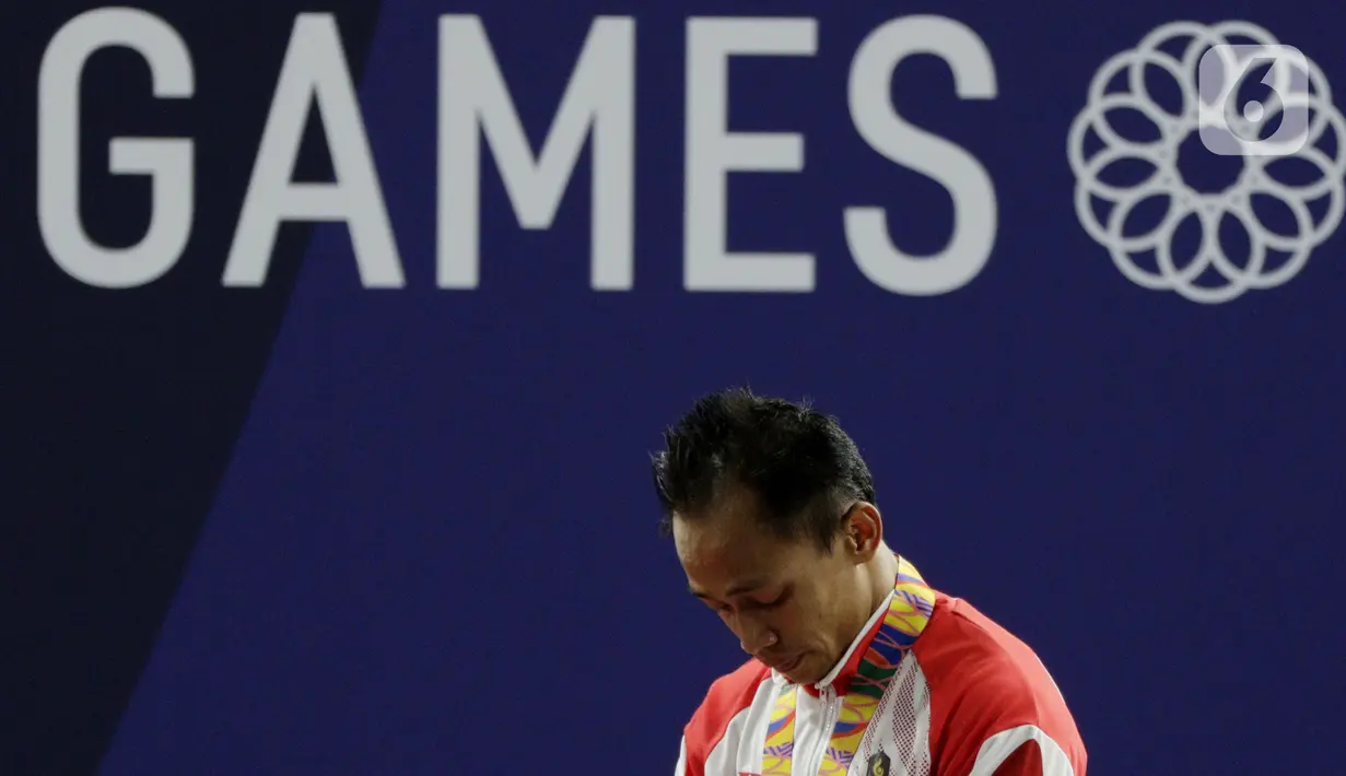 Lifter putra Indonesia, Suratman menangis saat naik podium usai mendapatkan medali perunggu SEA Games 2019 cabang angkat besi nomor 55 kg di Stadion Rizal Memorial, Manila, Minggu (1/12/2019). Dirinya meraih perak dengan total angkatan 250 kg. (Bola.com/M Iqbal Ichsan)