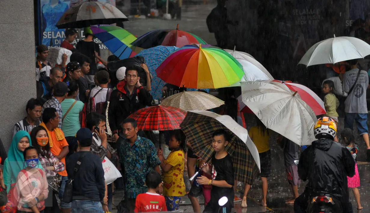 Sejumlah pengojek payung di salah satu tempat perbelanjaan di kawasan Tanah Abang, Jakarta, Selasa (9/2). Pada musim hujan seperti banyak pengojek payung dadakan yang mayoritas adalah anak-anak. (Liputan6.com/Faisal R Syam)