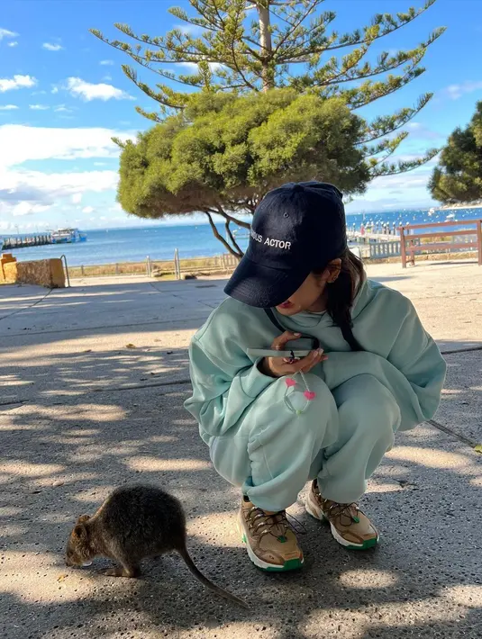 Sambil berlutut, Lisa mengamati quokka di sampingnya yang sedang makan. (Foto: Instagram/ lalalalisa_m)