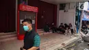Beberapa orang terlihat duduk di depan sejumlah toko dan perkantoran yang tutup di sekitar kompleks dengan Glodok Plaza, Jakarta, Kamis (16/1/2025). (Liputan6.com/Angga Yuniar)