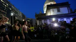 Sejumlah seniman wanita nekat bertelanjang dada saat menggelar demonstrasi di pusat kota Rio de Janeiro, Brasil, Rabu (1/6). Aksi dilakukan sebagai bentuk protes mereka terhadap maraknya kasus pemerkosaan dan kekerasan seksual. (REUTERS/Ricardo Moraes)