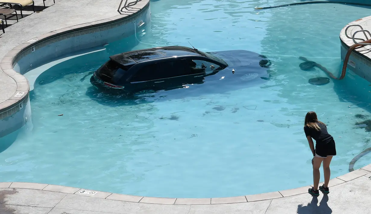Sebuah mobil terlihat di dalam kolam renang di Cheyenne Mountain Resort, Colorado Springs, (4/7). Seorang wanita berusia 73 tahun lolos dari cedera serius saat ia keliru menginjak pedal gas, bukannya rem. (Jerilee Bennett / The Gazette via AP)