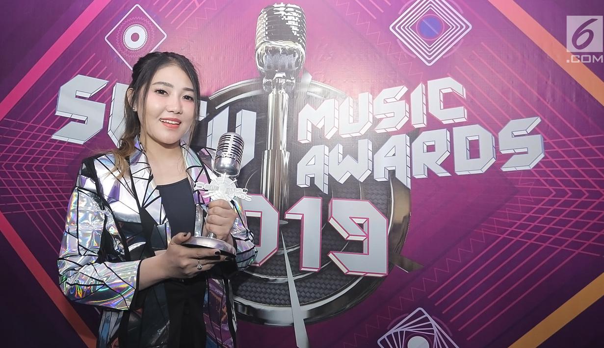 Penyanyi dangdut Via Vallen berpose dengan piala penghargaan usai acara SCTV Music Awards 2019 di Studio 6 Emtek City, Jakarta, Jumat (26/4). Via Vallen memboyong gelar Kategori Lagu Pop Paling Ngetop melalui "Meraih Bintang" yang sempat jadi Theme Song Asian Games 2018. (Fimela.com/Bambang E. Ros)