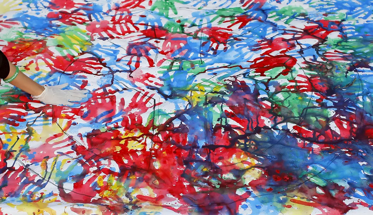 Seorang wanita membuat seni handprint selama festival memperingati Hari Perdamaian Internasional di Baghdad,Irak (21/9/2015). Perayaan diisi dengan kreativitas seni karya para pemuda dan pemudi Irak. (REUTERS/Thaier al-Sudani)