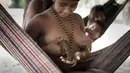 Wanita dari suku Awa menyusui seekor anak tupai di hutan bagian timur Brasil yang sangat dalam. Suku Awa merupakan suku yang hampir punah karena kebanyakan dari mereka banyak yang tewas pada zaman penjajahan kolonis Eropa. (Dailymai.co.uk)