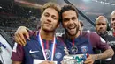 Penyerang PSG, Neymar Jr dan Dani Alves tersenyum sambil membawa Piala Prancis di Saint-Denis, Paris (8/5). Meski dalam kondisi cedera, Neymar tetap hadir menyaksikan timnya bertanding di final melawan Les Herbiers.  (AFP Photo/Franck Fife)