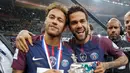 Penyerang PSG, Neymar Jr dan Dani Alves tersenyum sambil membawa Piala Prancis di Saint-Denis, Paris (8/5). Meski dalam kondisi cedera, Neymar tetap hadir menyaksikan timnya bertanding di final melawan Les Herbiers.  (AFP Photo/Franck Fife)