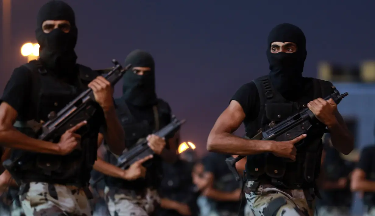 Angkatan bersenjata Saudi berbaris dalam sebuah parade di kota suci Arab Saudi di Mekkah (23/8). Bagi umat Islam yang mampu ibadah haji merupakan kewajiban yang harus dilakukan setidaknya sekali seumur hidup. (AFP Photo/Bandar Aldandani)