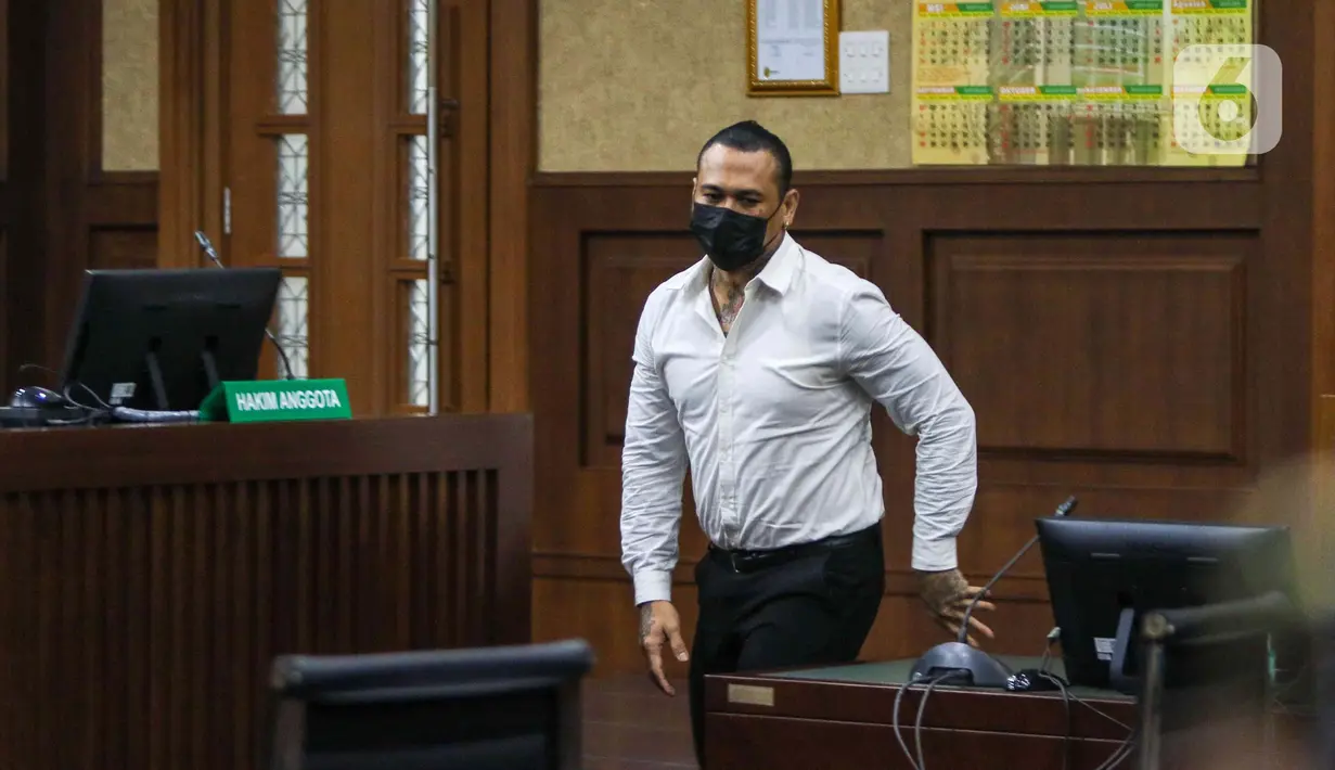 Terdakwa musisi I gede Ari Astina atau Jerinx mengikuti sidang tuntutan di PN Jakarta Pusat, Jakarta, Jumat (18/2/2022). Jerinx dituntut dua tahun penjara dan denda Rp50 juta subsider dua bulan kurungan atas kasus dugaan pengancaman kepada Adam Deni. (Liputan6.com/Herman Zakharia)