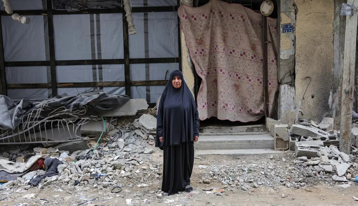Sabah Al-Turk, 64 tahun, berpose di depan rumahnya yang hancur di Jabalia, Jalur Gaza utara, pada 9 Februari 2025. (Bashar TALEB/AFP)