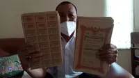 Oni Rahim saat memperlihatkan dokumen perjanjian piutang negara indonesia kepada keluarganya (Arfandi Ibrahim/Liputan6.com)
