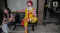 Seorang wanita duduk disamping patung Ronald di gerai makanan cepat saji McDonals's komplek pusat perbelanjaan Sarinah, Jakarta, Jumat (8/5/2020). Penutupan gerai ini dikarenakan pihak manajemen gedung sarinah akan merenovasi dan mengubah strategi bisnis. (Liputan6.com/Faizal Fanani)