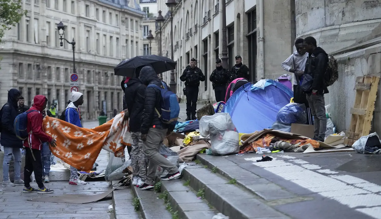 Polisi Prancis mengusir para migran dari sebuah kamp tenda darurat di sebelah Balai Kota Paris pada Selasa pagi, dalam operasi pembersihan terbaru terhadap orang-orang yang tidak memiliki tempat tinggal. (AP Photo/Michel Euler)