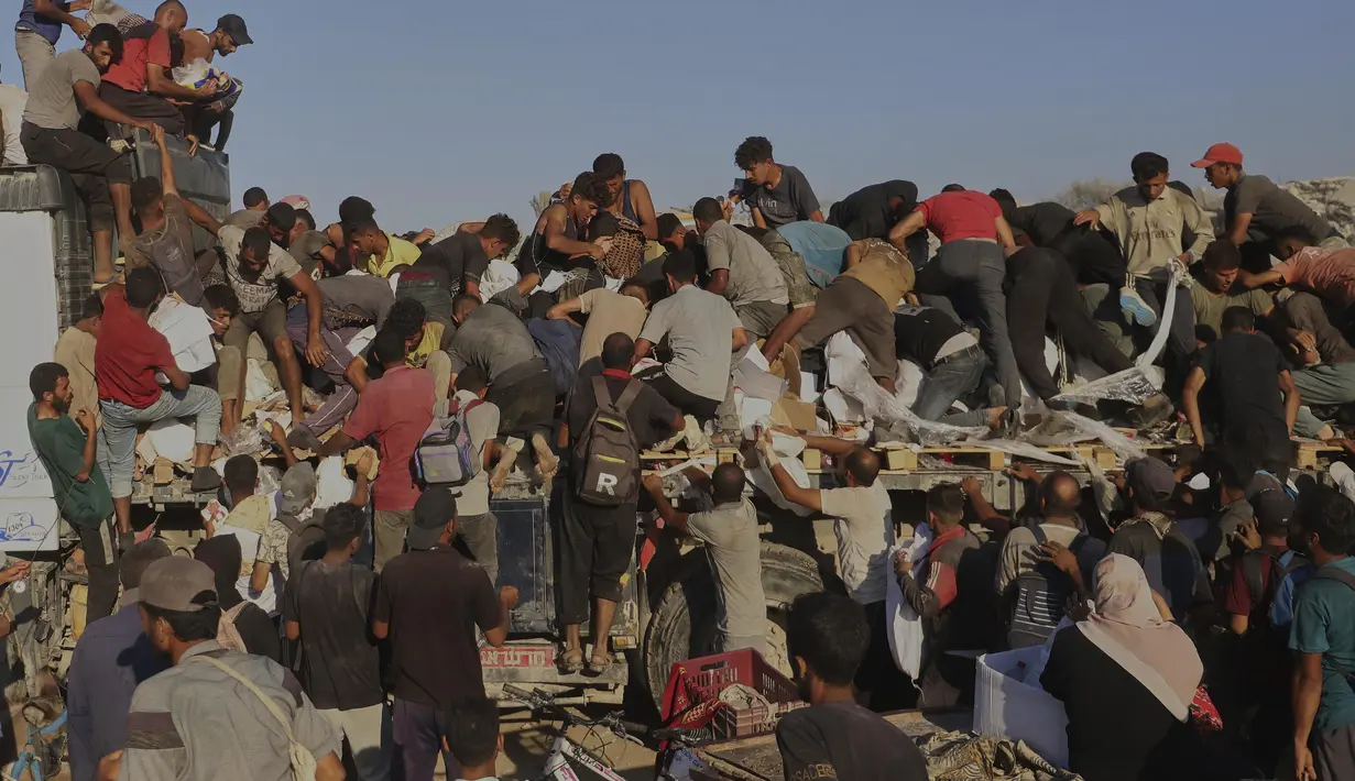 Kerumunan warga Palestina menyerbu truk yang membawa bantuan kemanusiaan di sepanjang koridor Morag dekat Rafah, Jalur Gaza selatan, Senin, 4 Agustus 2025. (AP Photo/Mariam Dagga)