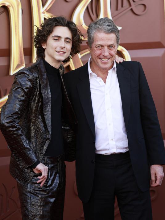 Chalamet melemparkan senyum lebarnya di samping Hugh Grant, yang memerankan Lofty si Oompa-Loompa. (JC Olivera / GETTY IMAGES NORTH AMERICA / Getty Images via AFP)