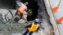 Pekerja memperbaiki jalan ambles di Jalan Daan Mogot, Tangerang, Banten, Senin (13/1/2020). Amblesnya jalan penghubung ke Jakarta ini diduga karena adanya kebocoran pipa PDAM Tirta Kerta Raharja milik Pemkab Tangerang yang mengikis struktur tanah. (merdeka.com/Magang/Muhammad Fayyadh)