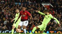 Gerard Pique menghentikan pergerakan Anthony Martial pada leg 1, babak perempat final Liga Champions yang berlangsung di Stadion Old Trafford, Manchester. Kamis (11/4). Barcelona menang 1-0 atas Man United. (AFP/Oli Scarff)