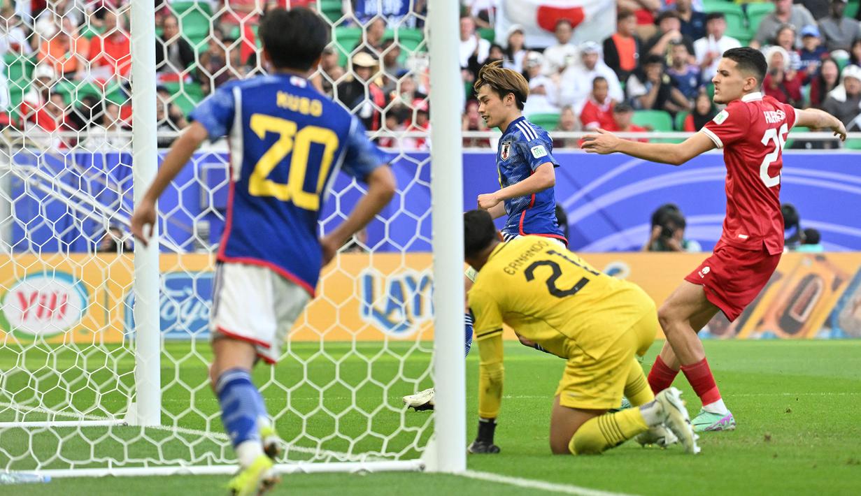 Kiper Timnas Indonesia, Ernando Ari Sutaryadi kebobolan gol kedua melalui sontekan striker Jepang, Ayase Ueda (tengah) pada laga ketiga Grup D Piala Asia 2024 di Al-Thumama Stadium, Doha, Qatar, Rabu (24/1/2024) malam WIB. (AFP/Hector Retamal)