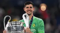 Penjaga gawang Real Madrid Thibaut Courtois merayakan trofi Liga Champions 1-0 atas Liverpool dalam pertandingan final di Stadion Stade de France, Prancis, Minggu (29/5/2022) dini hari WIB.&nbsp;(Paul ELLIS / AFP)