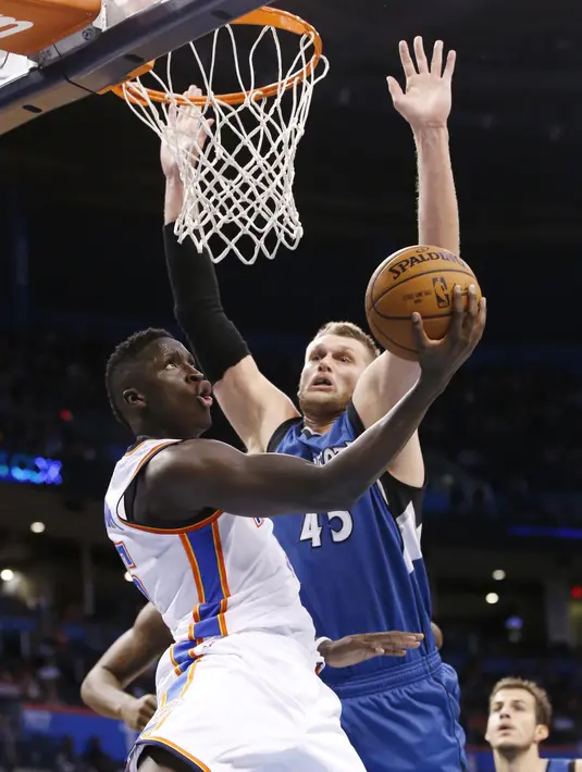 Pemain Oklahoma City Thunder, Victor Oladipo melakukan tembakan saat dihadang pemain Minnesota Timberwolves, Cole Aldrich #45 pada laga NBA basketball preseason game di Oklahoma City, Senin (17/10/2016) WIB. (AP/Sue Ogrocki)
