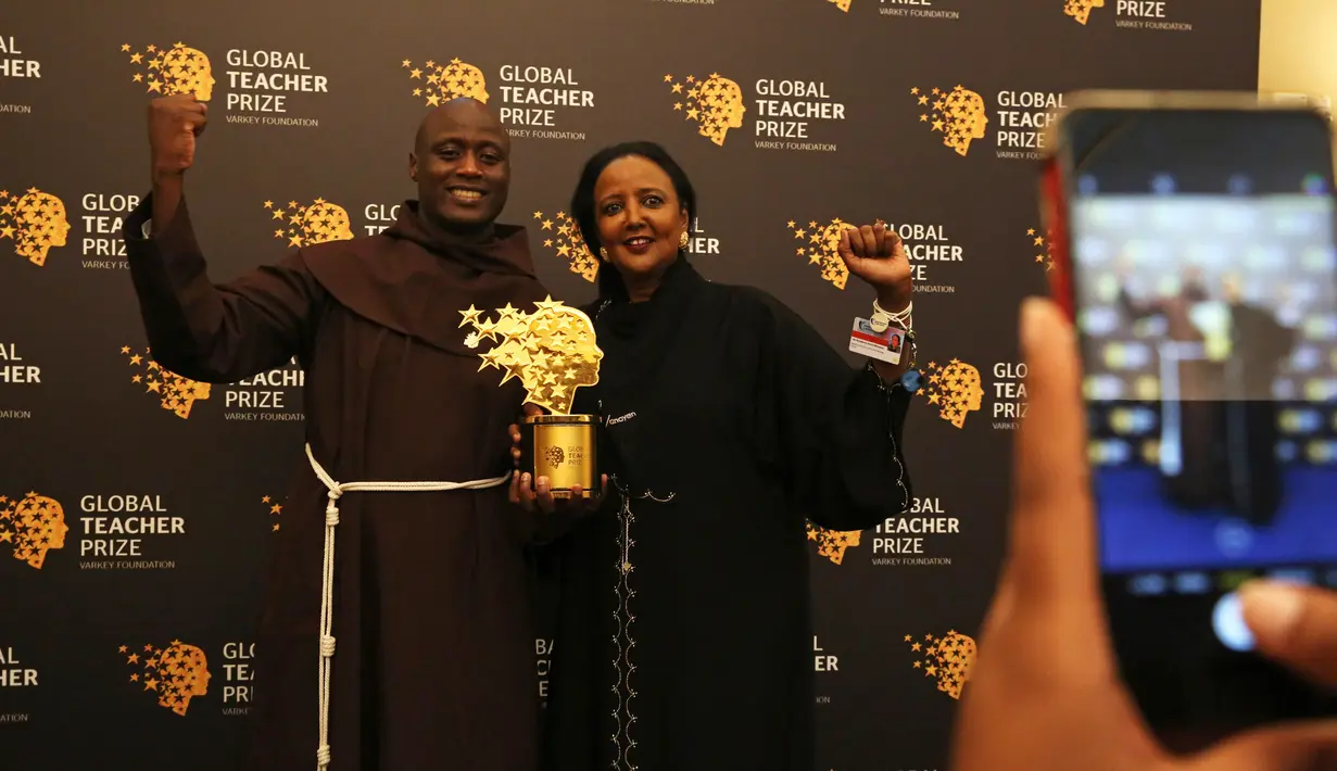 Guru mata pelajaran sains, Peter Tabichi berfoto bersama Sekretaris Kabinet Kenya Amina Mohamed seusai menerima penghargaan 2019 Global Teacher Prize di Dubai, Uni Emirat Arab, 24 Maret 2019. Guru dari wilayah pedesaan di Kenya itu dinobatkan sebagai pengajar terbaik di dunia. (AP/Jon Gambrell)